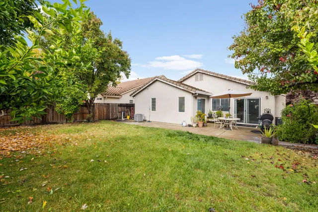 a view of a house with backyard and sitting area