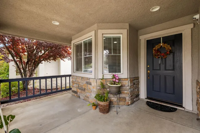 a view of a patio with a table and chairs and potted plants