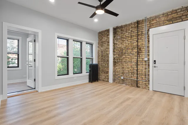 a view of an empty room with a window and a kitchen