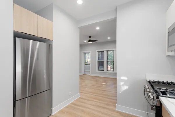 a view of a kitchen with a refrigerator and wooden floor