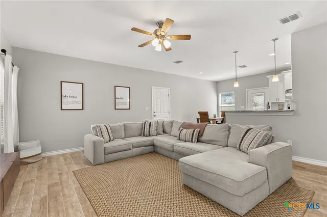a living room with furniture and a ceiling fan