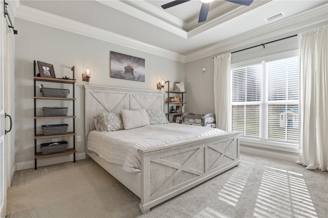 127 West Stewart Street Pelzer, SC 29669 - Photo 7 of 23 This tranquil bedroom features a tray ceiling, crown molding, and plush carpet, creating a serene retreat.