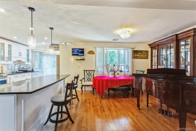 a very nice looking dining room with kitchen island furniture a large window and stainless steel appliances