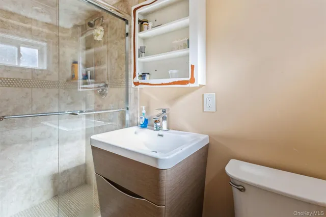 a bathroom with a sink a toilet and shower