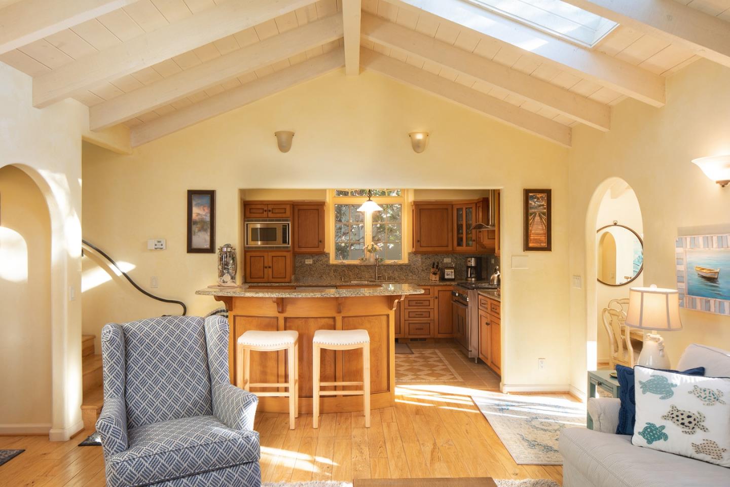 26335 Rio Avenue Carmel, CA 93923 - Photo 4 of 13 a living room with a couch and a dining table with wooden floor