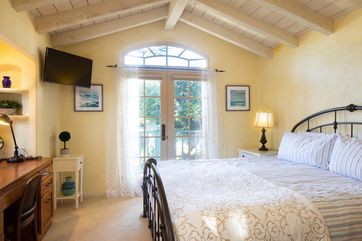 26335 Rio Avenue Carmel, CA 93923 - Photo 9 of 13 a bedroom with a bed and a chandelier