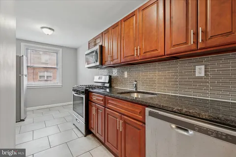 a kitchen with stainless steel appliances granite countertop a sink stove and cabinets