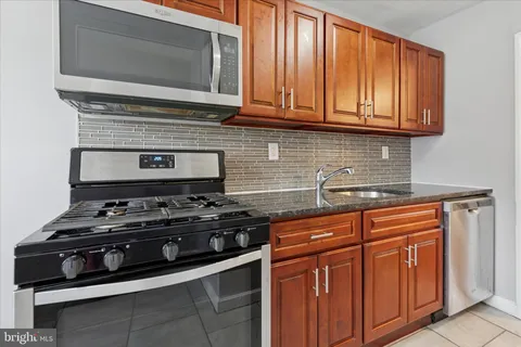 a kitchen with stainless steel appliances granite countertop a stove and a microwave