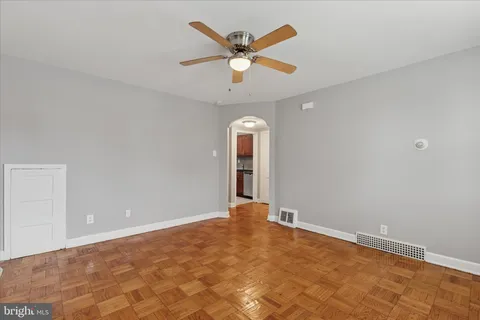an empty room with ceiling fan and window