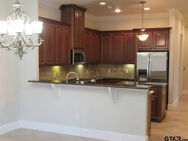 a kitchen with stainless steel appliances granite countertop a sink a stove and a microwave