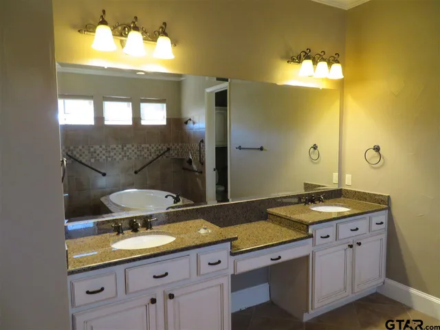 a bathroom with a granite countertop sink a toilet and a mirror