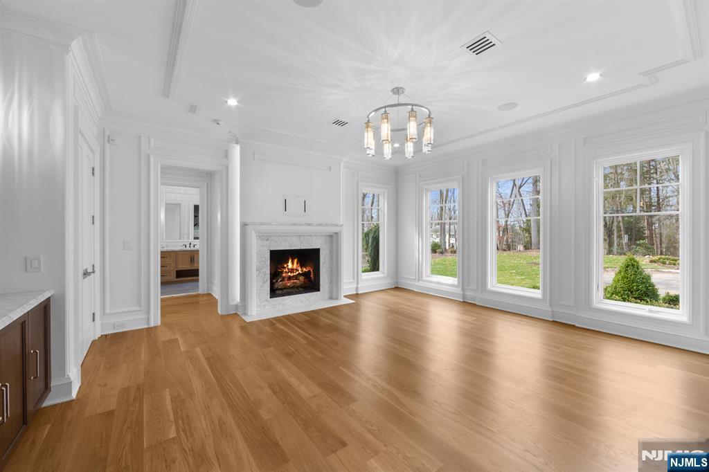 104 Chestnut Ridge Road Saddle River, NJ 07458 - Photo 20 of 47 an empty room with wooden floor fireplace and windows