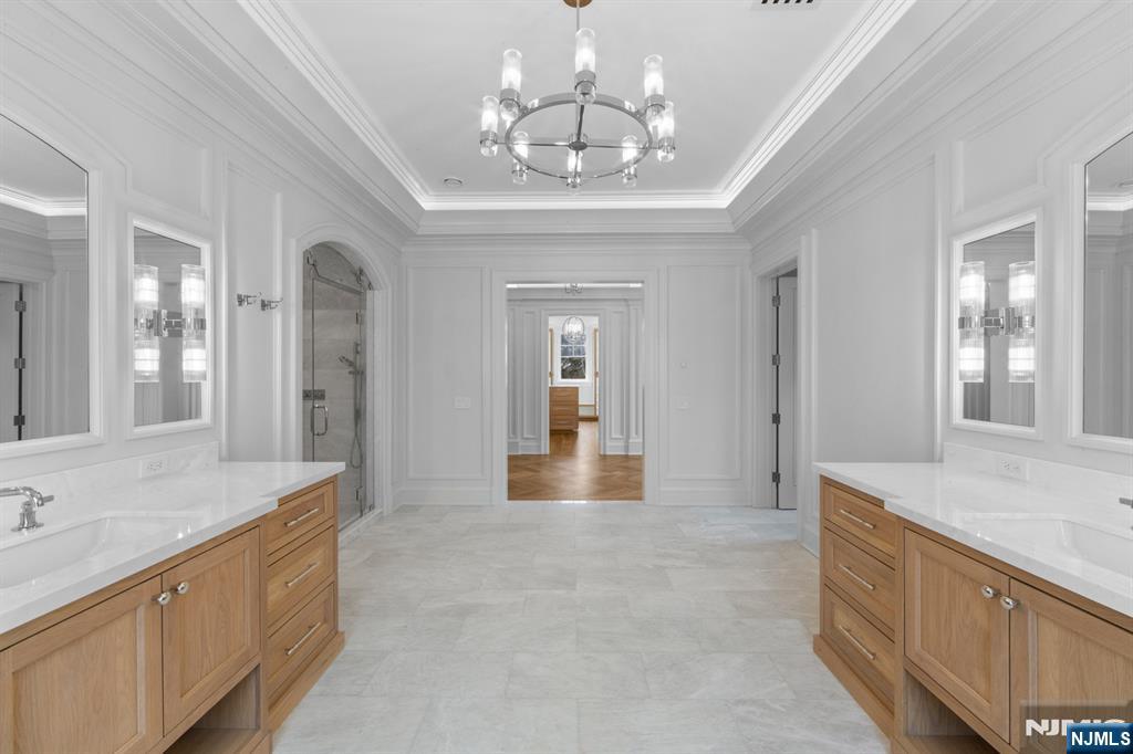 104 Chestnut Ridge Road Saddle River, NJ 07458 - Photo 34 of 47 a large en suite bathroom with a granite countertop double vanity sink a mirror and a bathtub