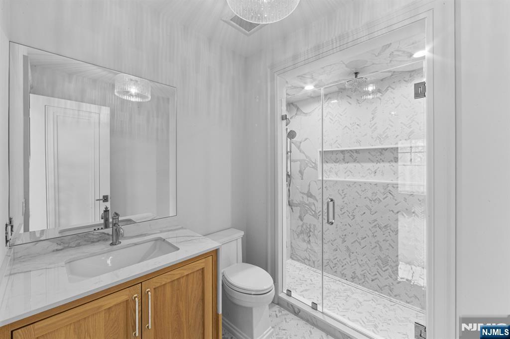 104 Chestnut Ridge Road Saddle River, NJ 07458 - Photo 40 of 47 a bathroom with a granite countertop sink a toilet and shower