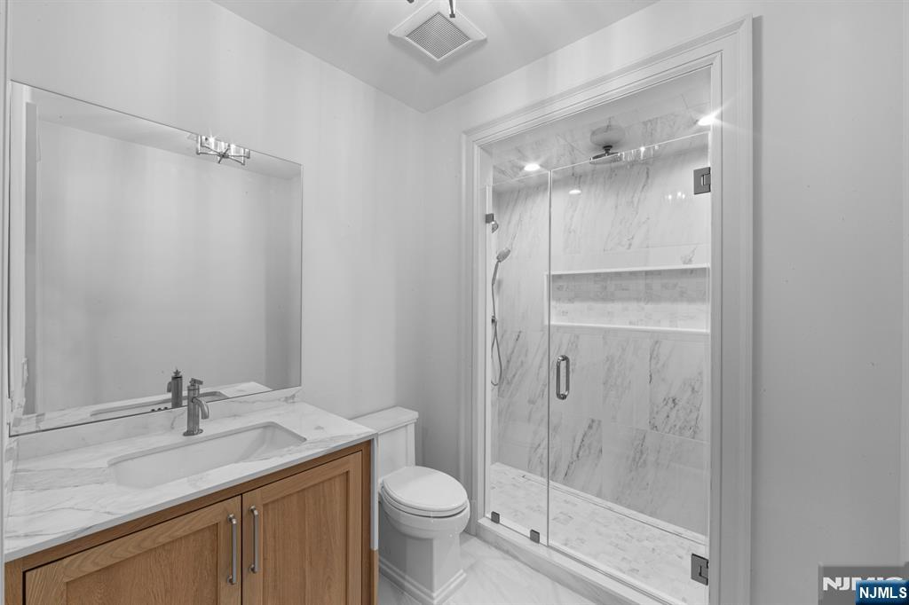 104 Chestnut Ridge Road Saddle River, NJ 07458 - Photo 42 of 47 a bathroom with a granite countertop sink toilet and shower