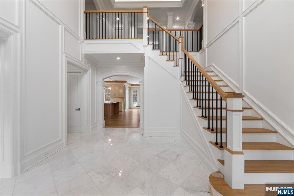 104 Chestnut Ridge Road Saddle River, NJ 07458 - Photo 6 of 47 a view of staircase with white walls and wooden floor