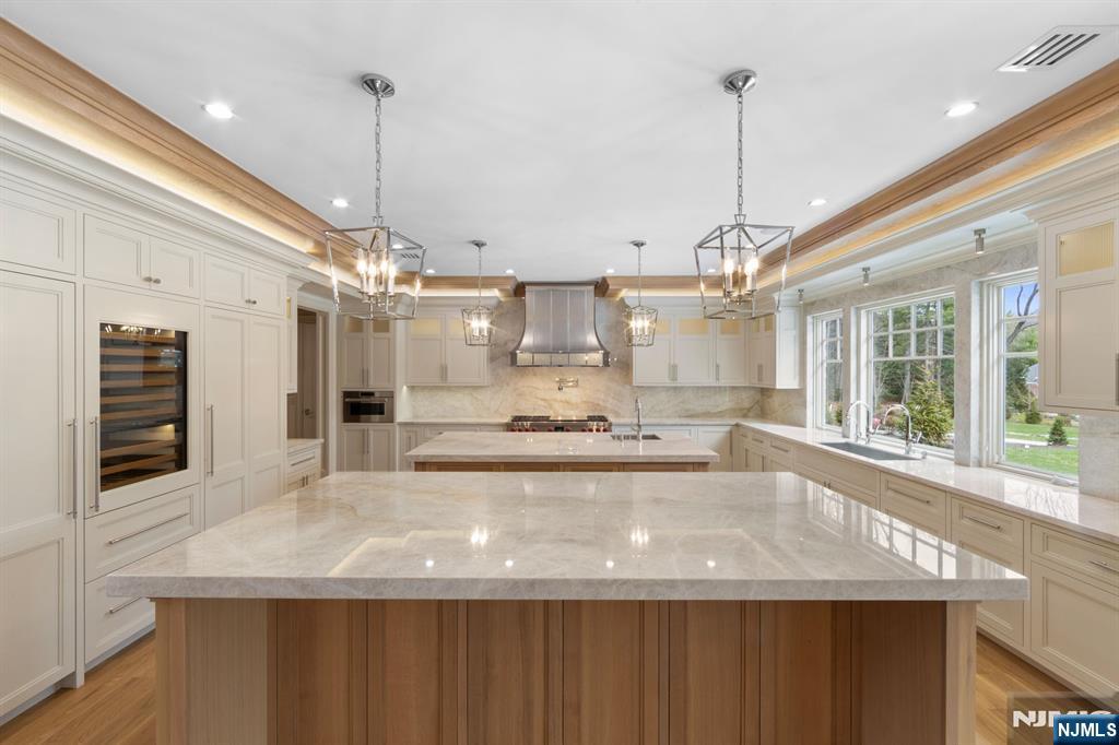 104 Chestnut Ridge Road Saddle River, NJ 07458 - Photo 9 of 47 a large kitchen with kitchen island a large island in it