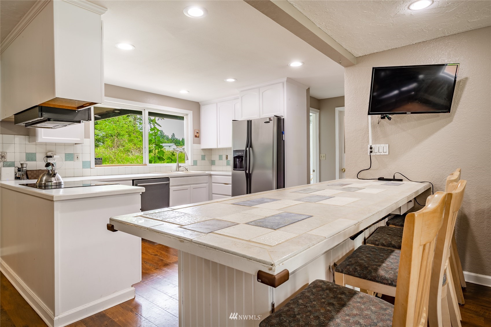 5577 E Road Bellingham, WA 98226 - Photo 32 of 40 a kitchen with a table chairs refrigerator and microwave