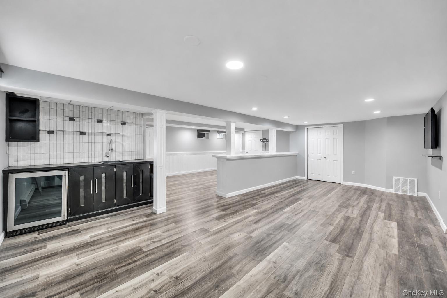 19 Joan Road Bay Shore, NY 11706 - Photo 40 of 50 Spacious lower level featuring wood-finish flooring, recessed lighting, and a built-in wet bar with a beverage refrigerator