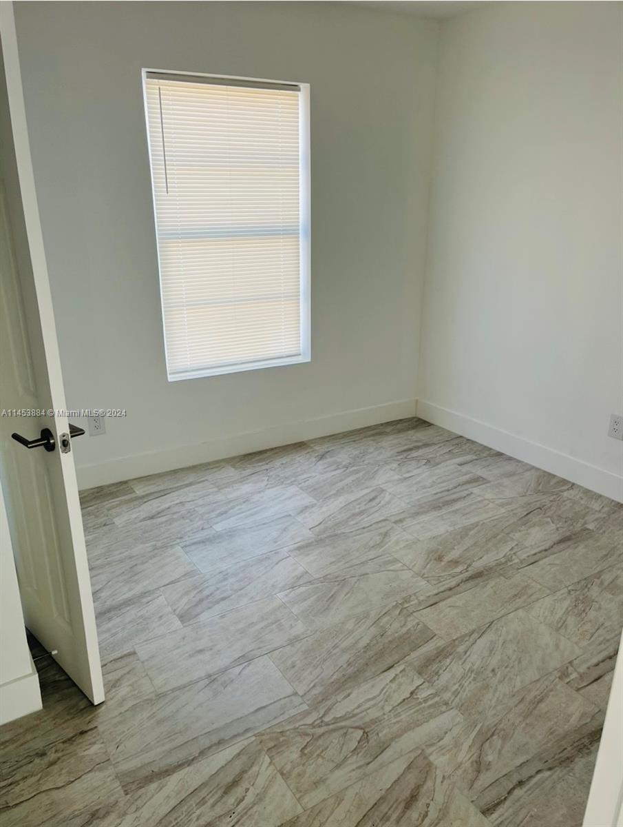 6955 Rue Vendome Miami Beach, FL 33141 - Photo 36 of 43 an empty room with wooden floor and windows