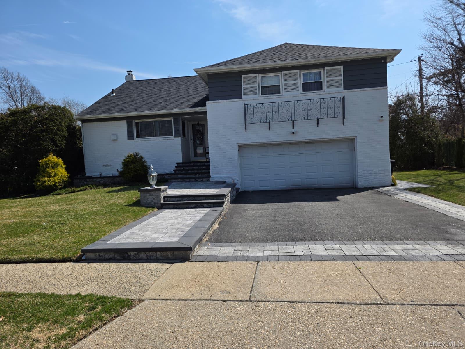 838 Pepperidge Road Westbury, NY 11590 - Photo 13 of 13 a front view of a house with a yard and a garage