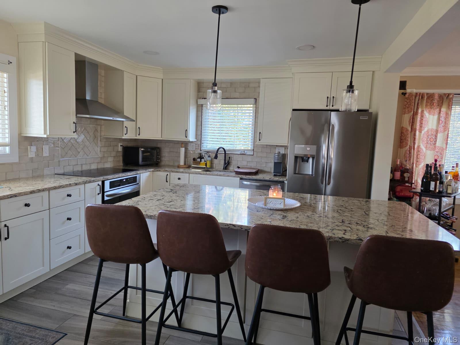 838 Pepperidge Road Westbury, NY 11590 - Photo 5 of 13 a kitchen with stainless steel appliances granite countertop a dining table chairs refrigerator and sink
