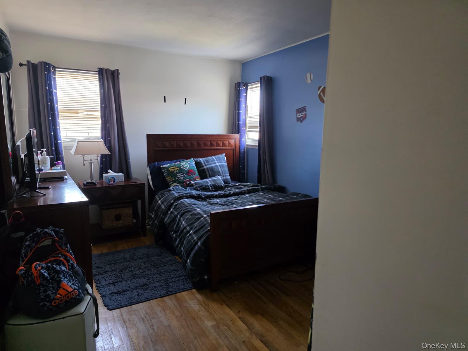 838 Pepperidge Road Westbury, NY 11590 - Photo 8 of 13 a bed sitting in a bedroom next to a window with tv and a fireplace