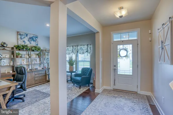 a kitchen with stainless steel appliances granite countertop a stove top oven a refrigerator a sink and a dining table with wooden floor