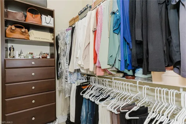 a view of walk in closet with clothes and shoes