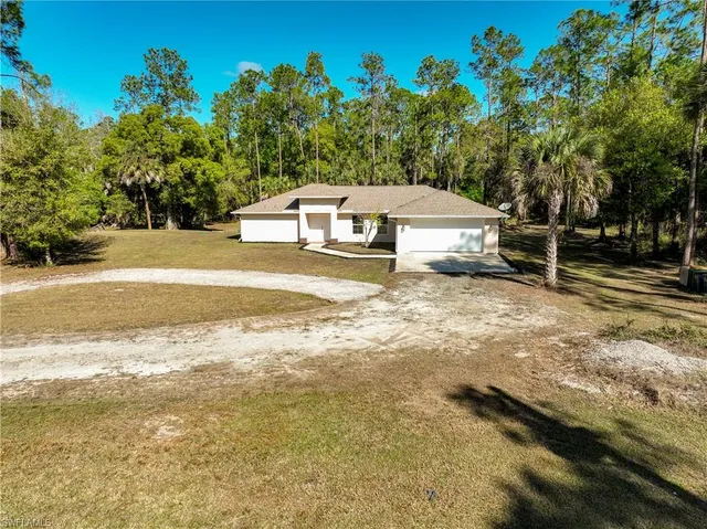 a front view of a house with a yard and trees