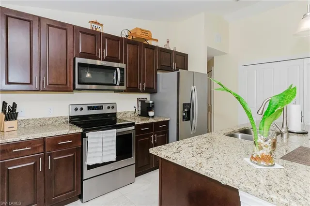 a kitchen with stainless steel appliances granite countertop a stove refrigerator and microwave