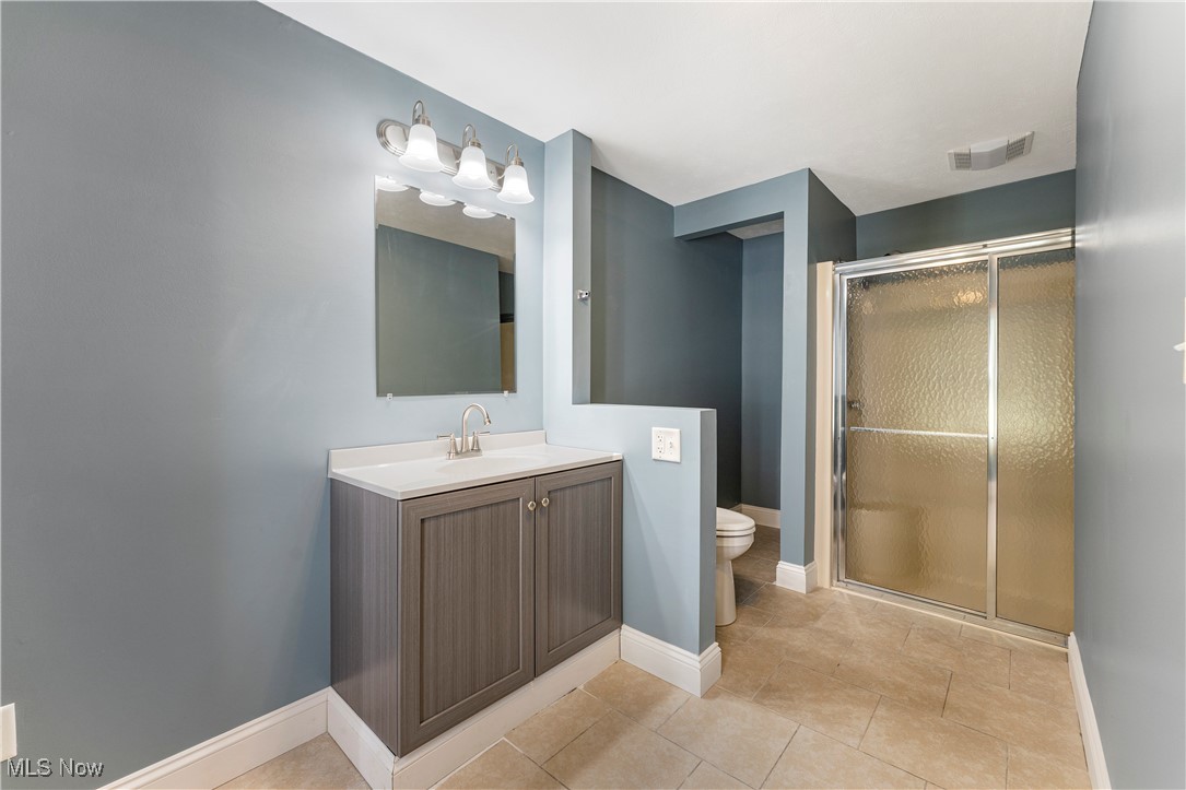 1623 Spangler Road Northeast Canton, OH 44714 - Photo 17 of 28 Full bathroom with vanity, a stall shower, and light tile patterned floors