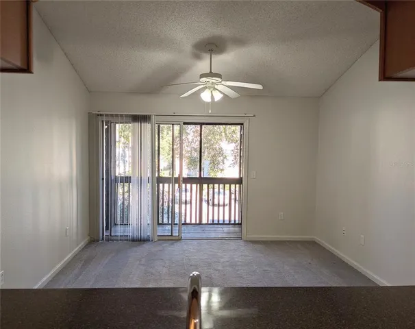 an empty room with windows and ceiling fan