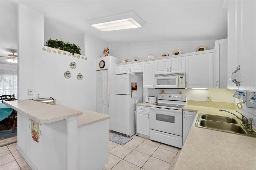 80 Roxboro Drive Palm Coast, FL 32164 - Photo 12 of 39 a kitchen with a sink stove and refrigerator