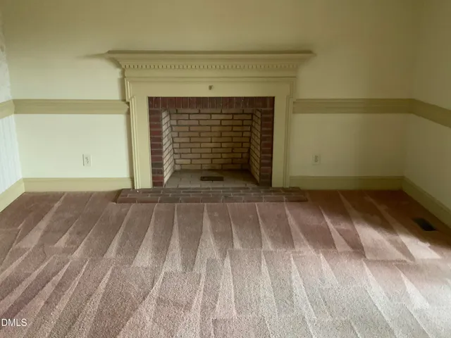 a view of a livingroom with an empty space and a window