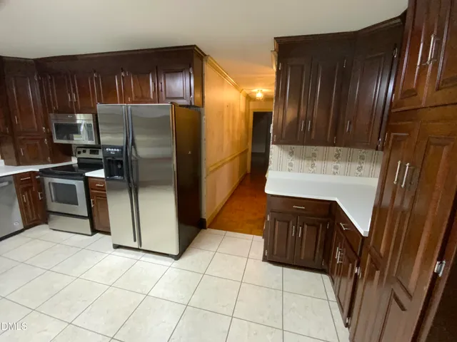 a kitchen with granite countertop a refrigerator and a stove top oven