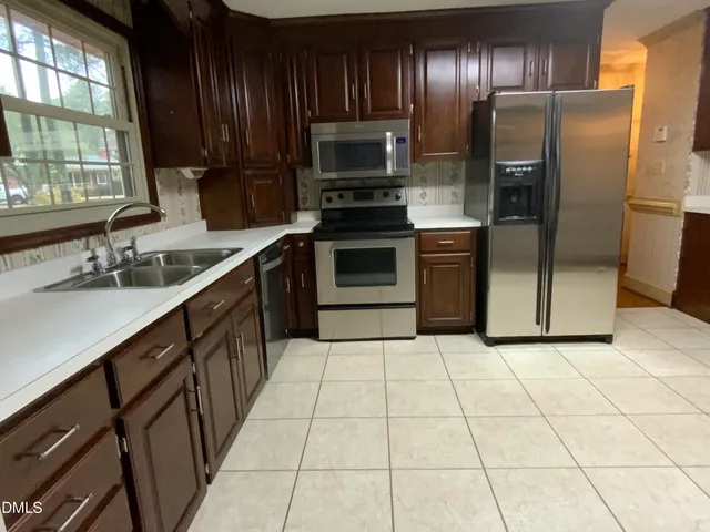 a kitchen with stainless steel appliances a refrigerator sink and cabinets