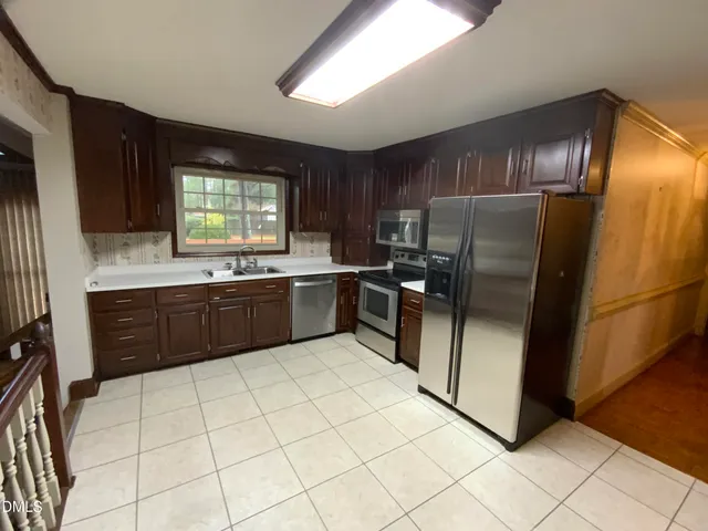 a kitchen with granite countertop a refrigerator and a stove top oven
