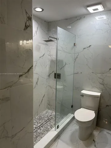 a bathroom with a toilet and a shower