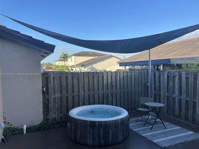 a view of a backyard with table and chairs with wooden fence