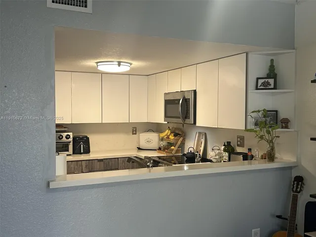 a kitchen with a sink cabinets and window