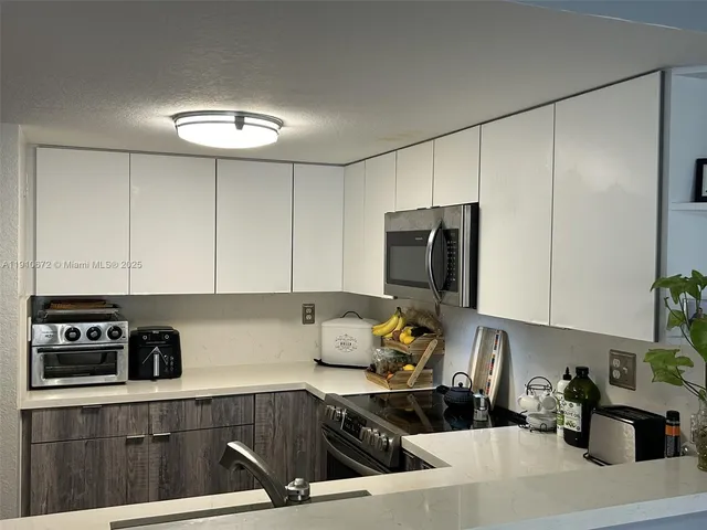 a kitchen with stainless steel appliances a stove a sink a refrigerator and cabinets