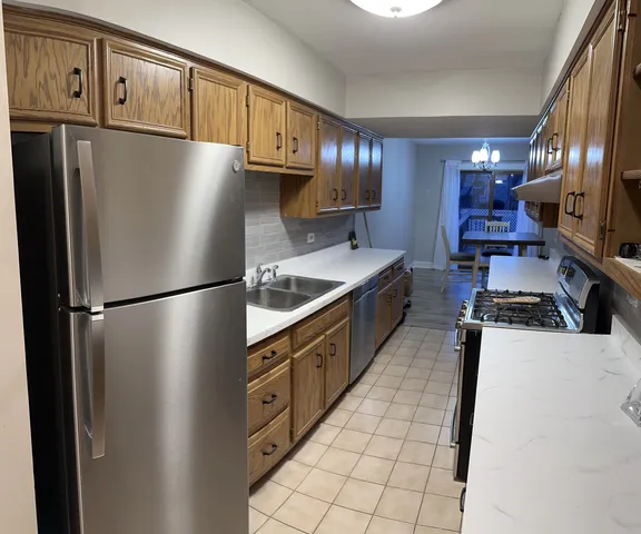 a kitchen with stainless steel appliances granite countertop a refrigerator a stove a sink dishwasher and a refrigerator