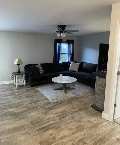 a living room with furniture and a wooden floor