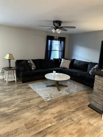 a living room with furniture and a wooden floor