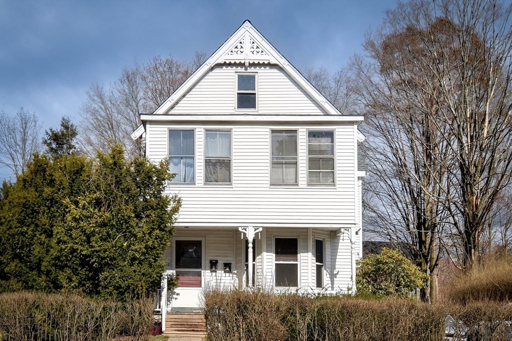 a view of a white house next to a yard
