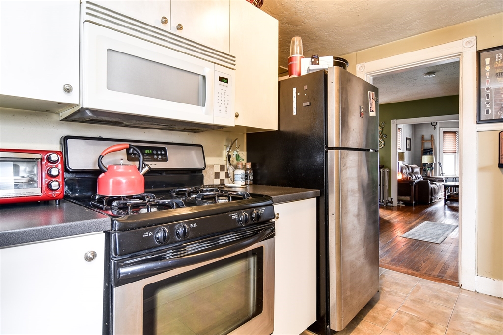 30 Winter Street Framingham, MA 01702 - Photo 7 of 23 a kitchen with stainless steel appliances granite countertop a stove and a refrigerator