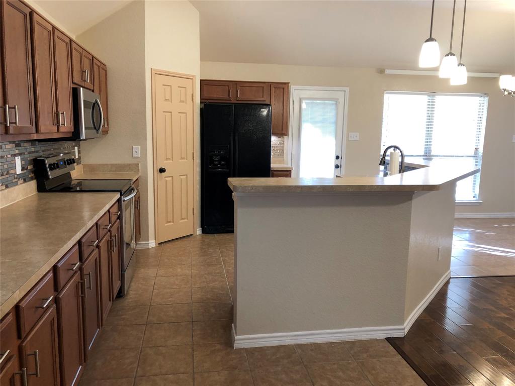 4005 Vista Greens Drive Fort Worth, TX 76244 - Photo 2 of 6 a kitchen with stainless steel appliances a sink stove and cabinets