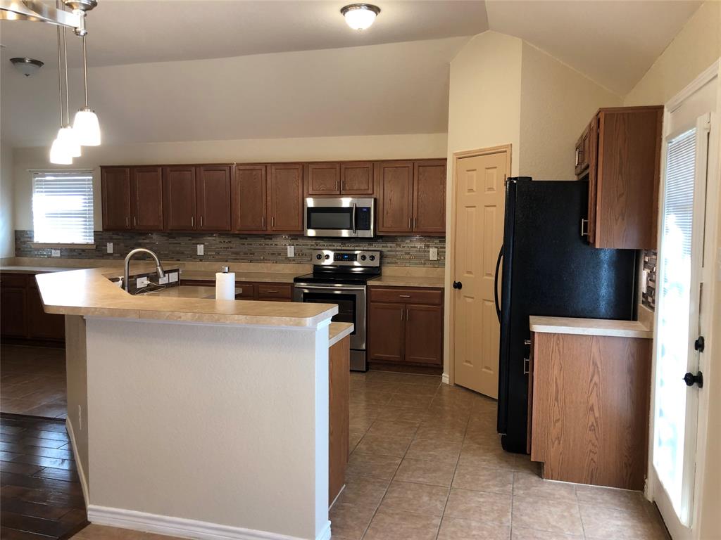 4005 Vista Greens Drive Fort Worth, TX 76244 - Photo 3 of 6 a kitchen with stainless steel appliances a refrigerator a sink a stove a microwave a counter top and oven