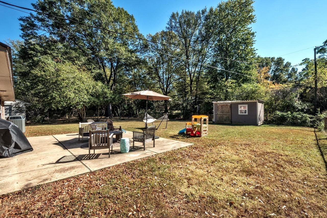 5135 Princeton Road Memphis, TN 38117 - Photo 22 of 24 a backyard of a house with table and chairs under an umbrella